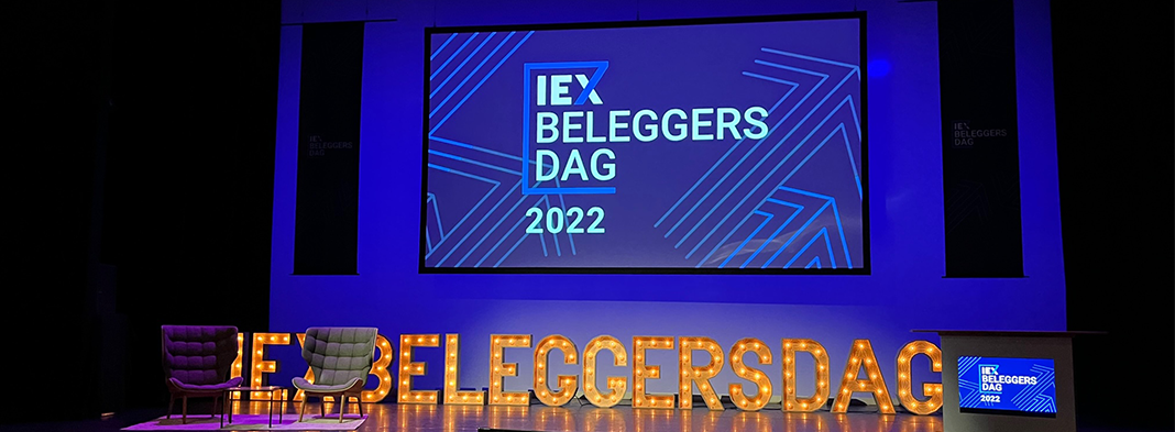 IEX Beleggersdag podium, paars verlicht met letters