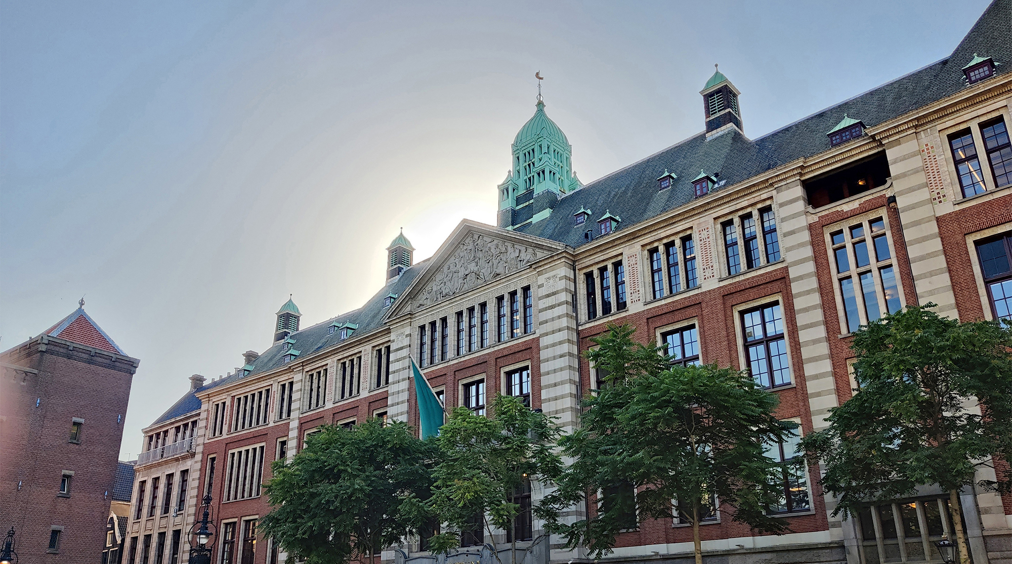 foto van de gevel van het beursgebouw in Amsterdam met de zon vlak achter het gebouwd