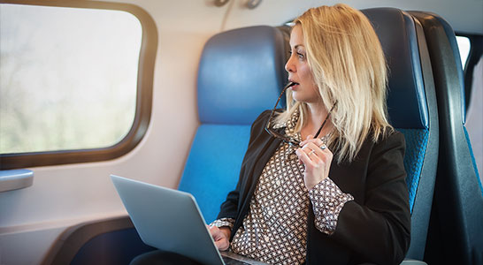 vrouw in NS trein met laptop kijkt nonchelant naar raam